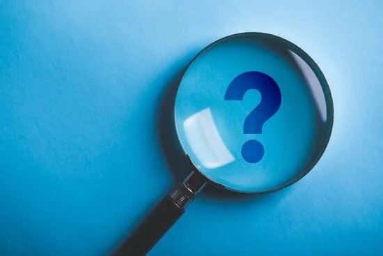 Magnifying glass over a question mark